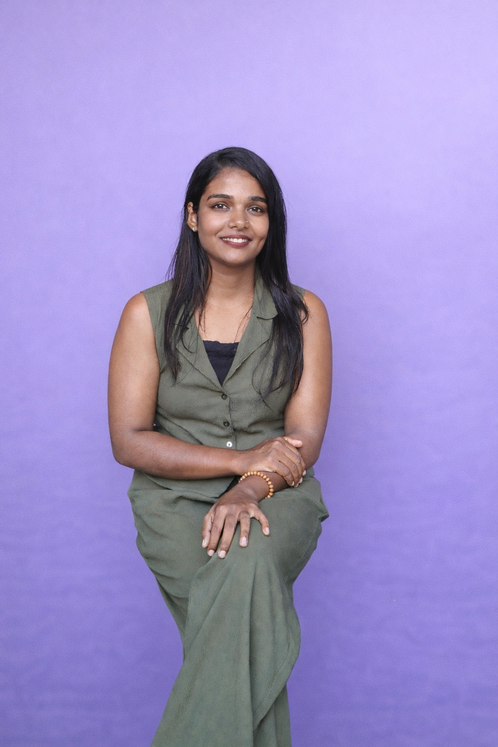 a woman sitting in a chair with formal dress with lavender background